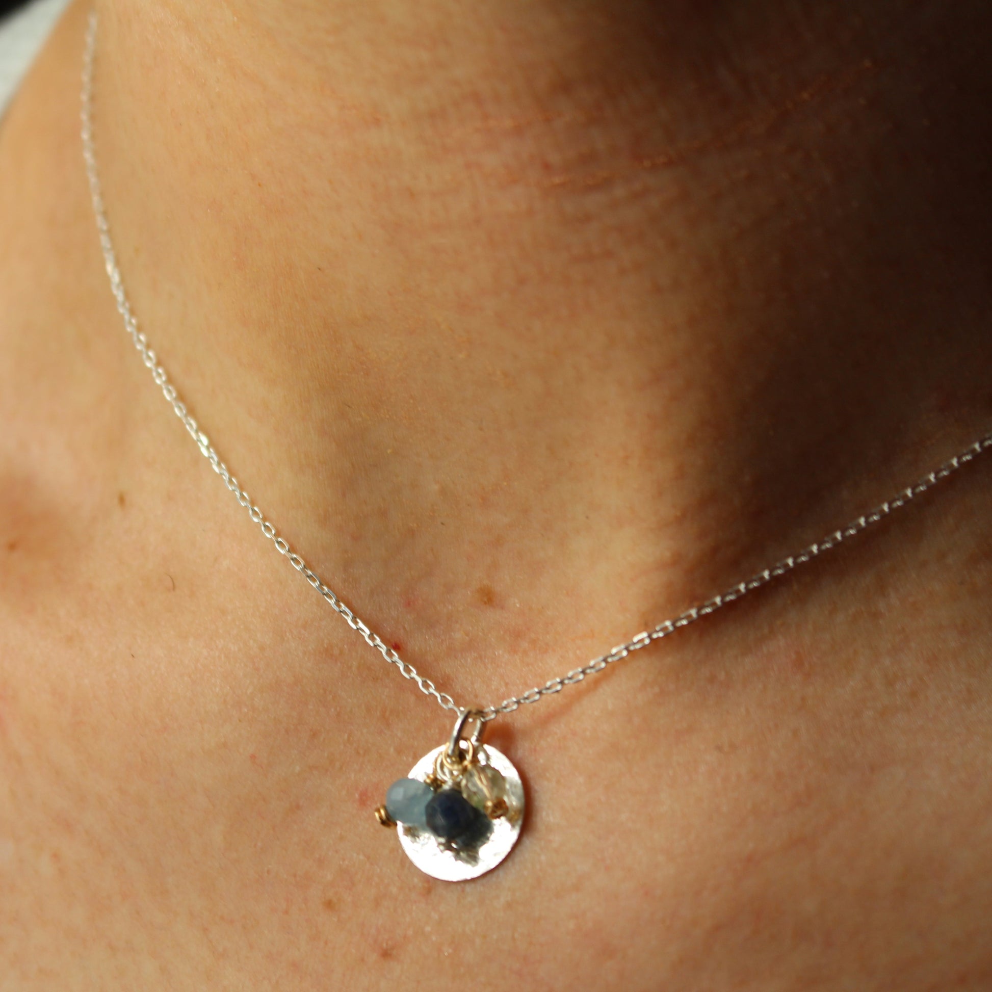3-Stone Birthstone Circle Charm Pendant Sterling Silver on a person's neck against a neutral background