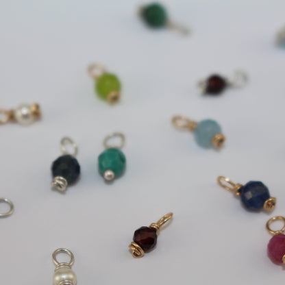 Assorted colorful birthstone charms on a white background